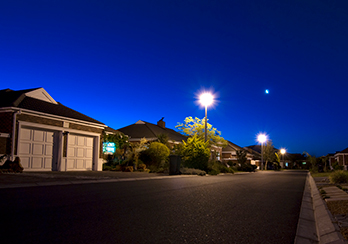 Suburban neighborhood at dusk with streetlights on