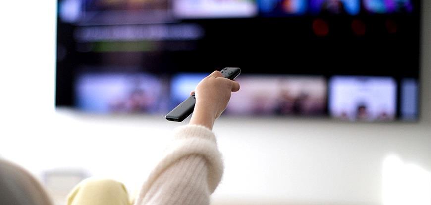 Fingers adjusting the settings on a digital thermostat