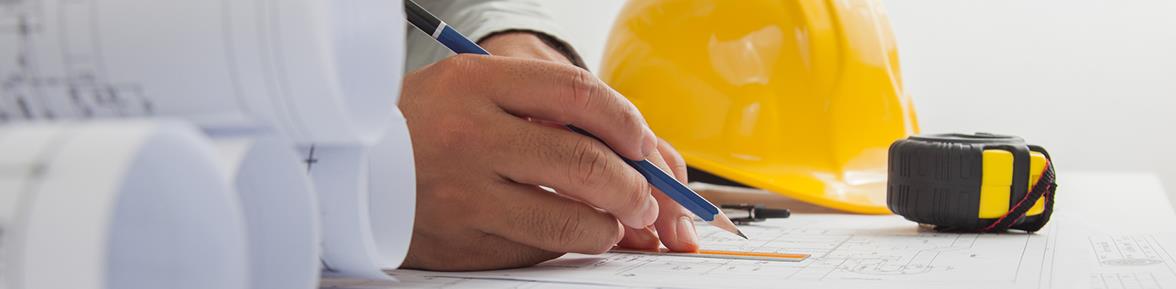 Closeup of hands marking up a blueprint with a pencil