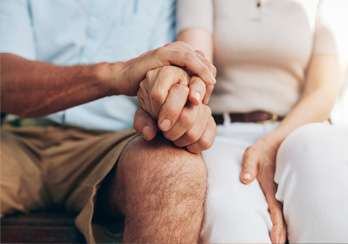 Pair of hands, right hand holding a pen and left hand punching keys on a calculator