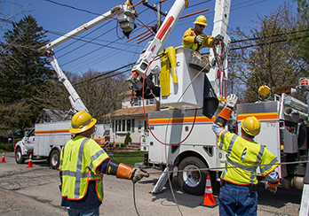 Three utility workers with a cherry picker at an external worksite