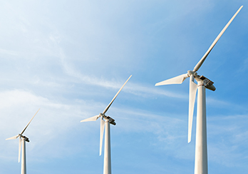 Two windmills with a blue sky in the background