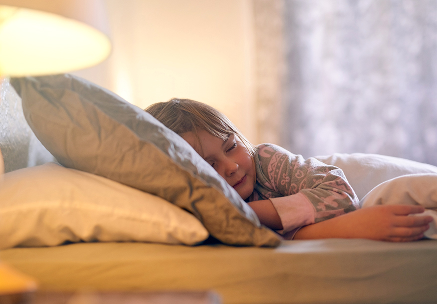 A child in bed covered by warm blankets
