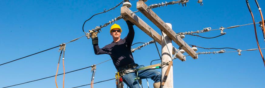 A technician working on a utility pole