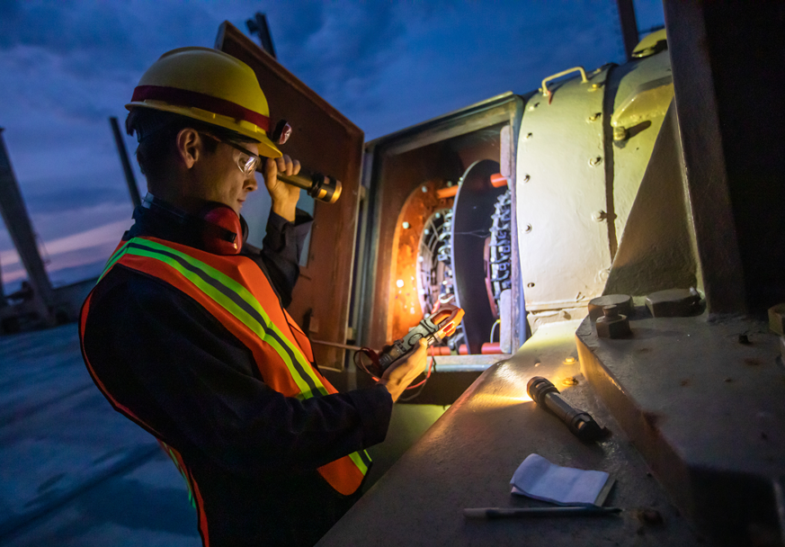 Snapped utility pole and transformer lying across wires