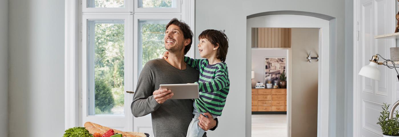 Man in kitchen with son looking at LED
