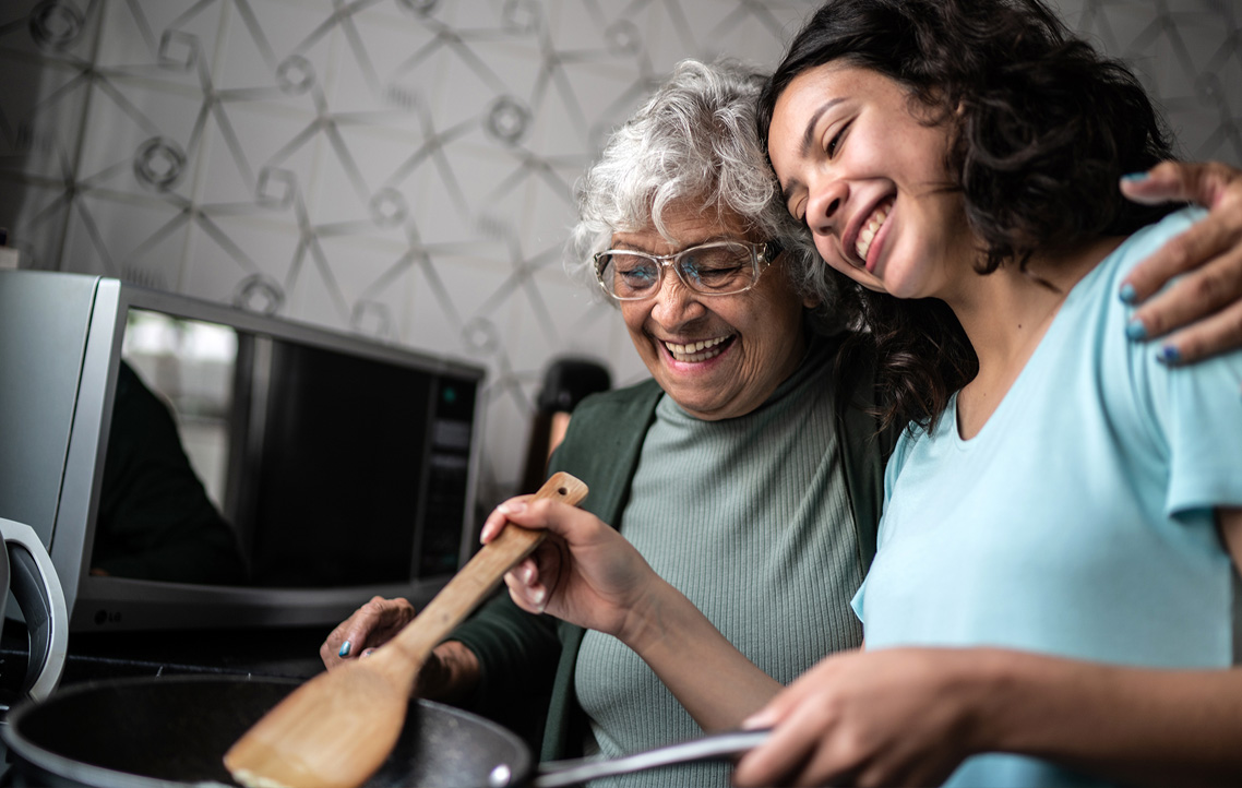 Grandma and granddaughter in kitchen smiling