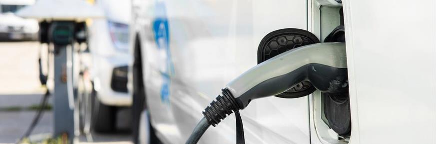 white ev getting charged