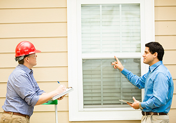 Two PSEG Long Island technicians assessing a window for energy efficiency