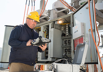 A PSEG Long Island technician examining diagnostics at an electricity substation