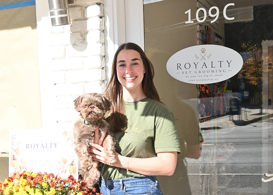 Rachel DeMartin, owner of Royalty Pet Grooming, holds Winston in front of her shop, one of two women-owned businesses in Port Washington that received grants from PSEG Long Island.
