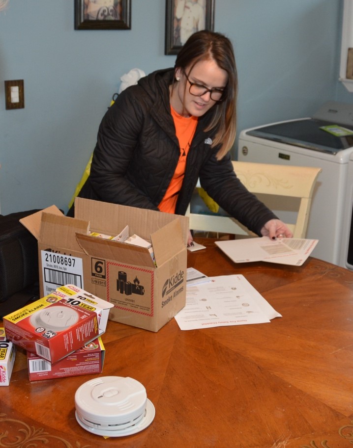 PSEG Long Island’s Brittany Venturo of Smithtown assembles smoke alarms in a New Hyde Park home—doing her part to keep local families safe by participating in the American Red Cross “Sound the Alarm” campaign.