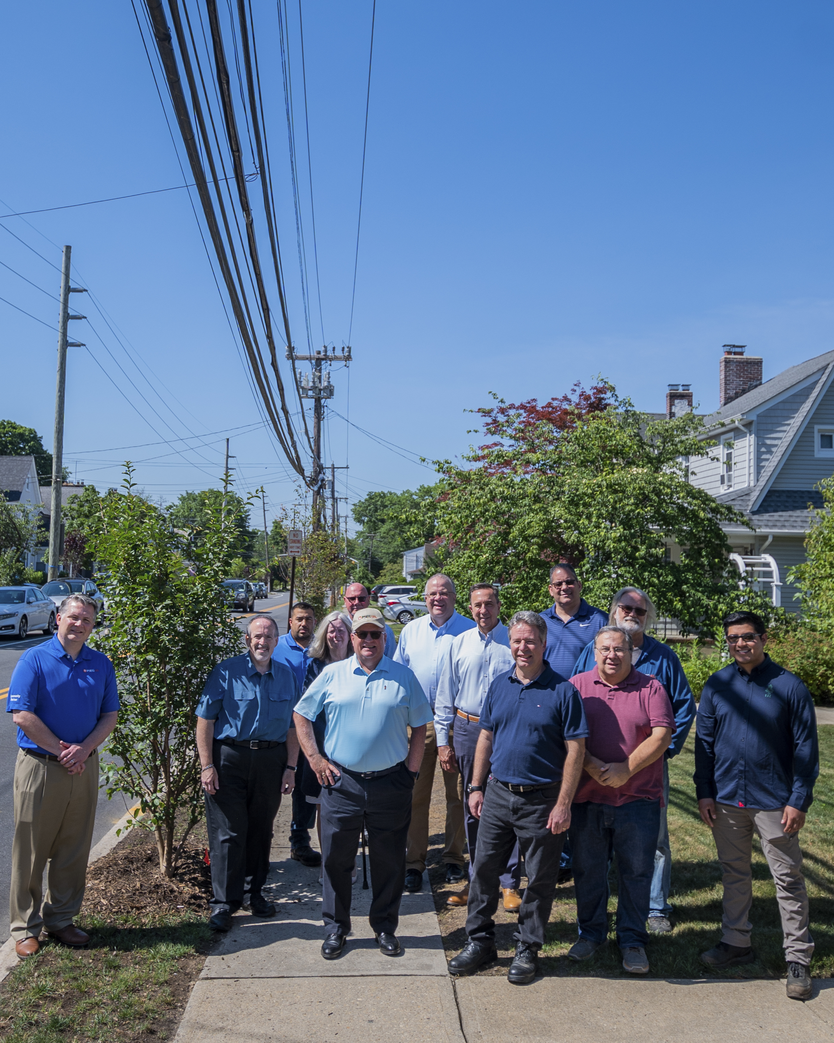 Floral Park officials, including Village Trustee Mike Longombardi (second from left), Deputy Mayor Lynn Pombonyo (fourth from left), Public Works Superintendent Kevin Ginnane (fifth from left), Mayor Kevin Fitzgerald (seventh from left) and Village Trustee Frank Chiara (eighth from left) joined PSEG Long Island personnel on June 30 to celebrate the planting of ornamental, wire-friendly trees on Plainfield Avenue. The trees replace taller pin oaks that posed hazards to the power lines during severe weather.